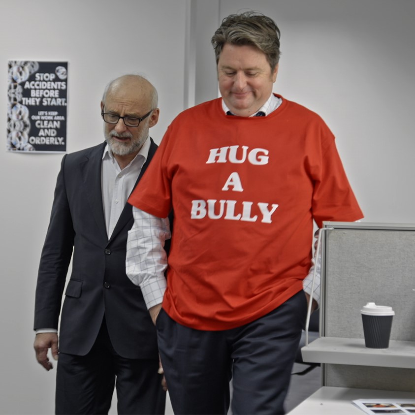 Man in red shirt promotes anti-bullying message.