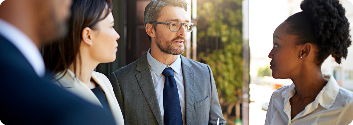 Professionals engaged in a business discussion outdoors.