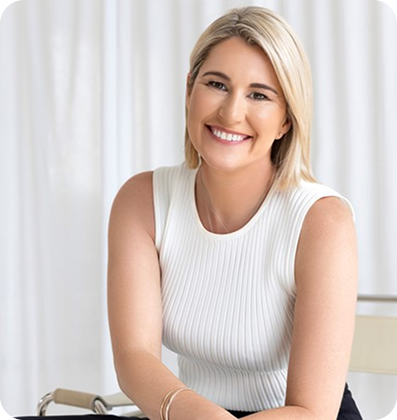 Smiling woman in a white top sitting.