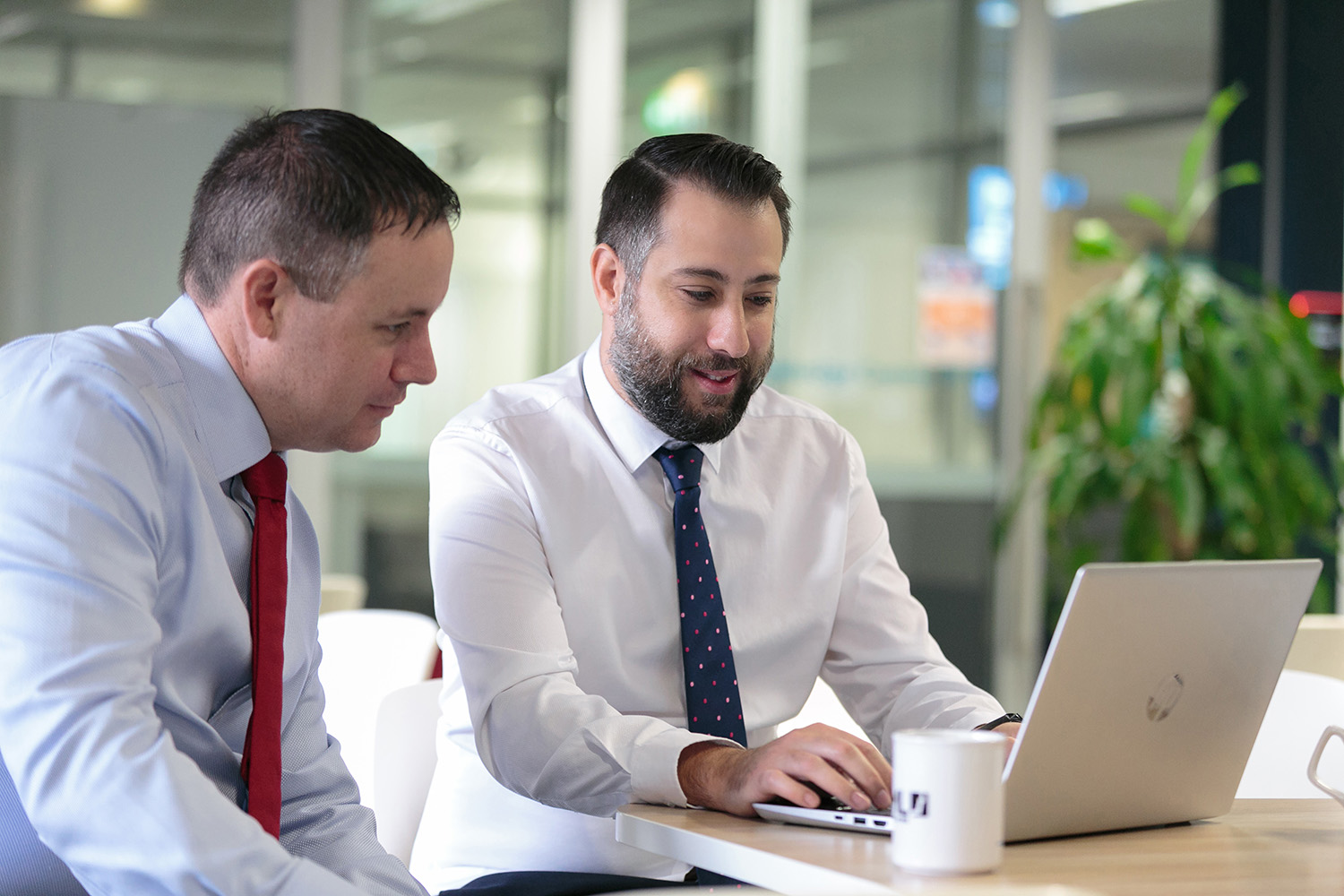 Two professionals discussing over a laptop
