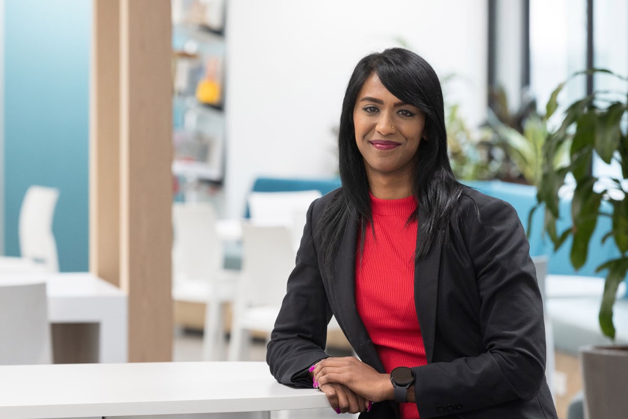 Confident professional woman posing in a modern office.