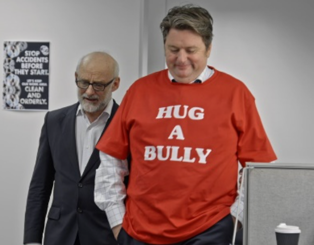 Man wearing 'Hug A Bully' shirt in office
