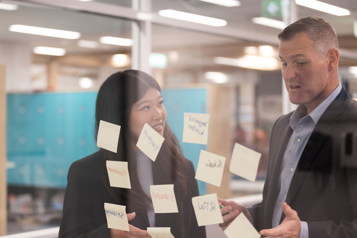 Two professionals discussing ideas with sticky notes.