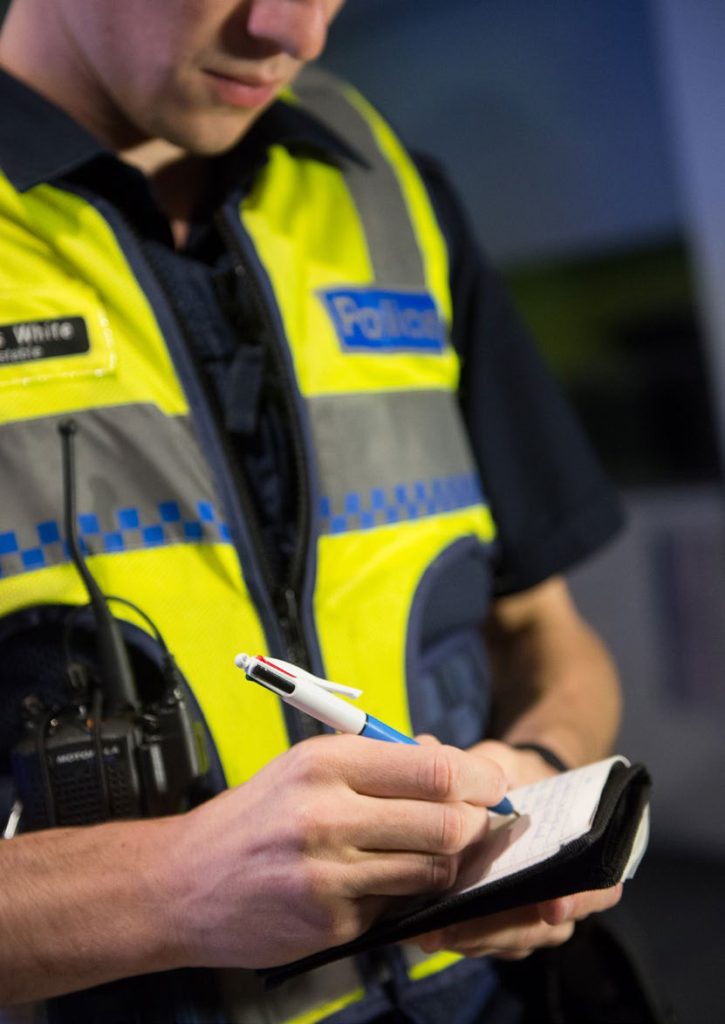 Police officer writing notes in a notebook.