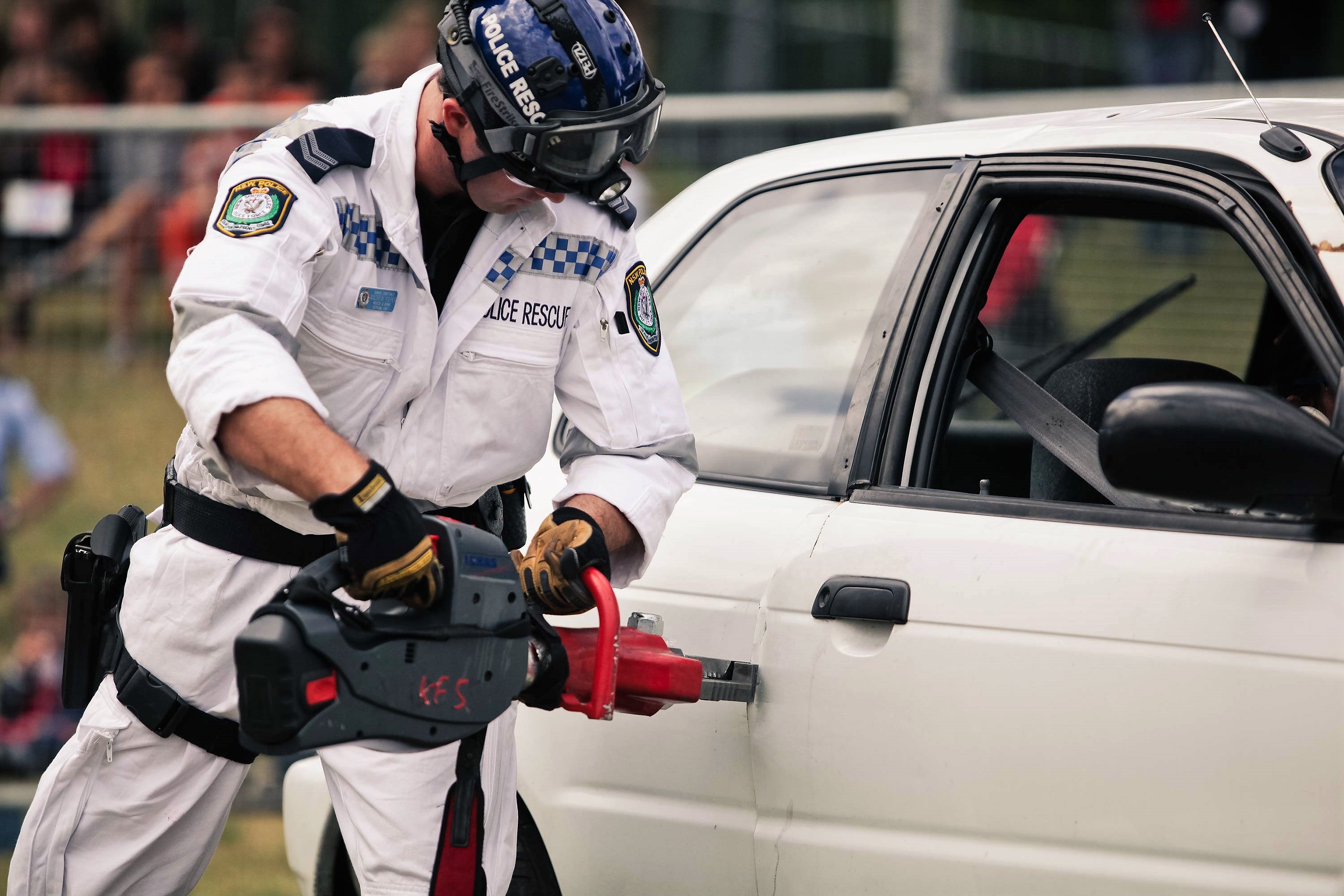 Police officer using a tool on a vehicle