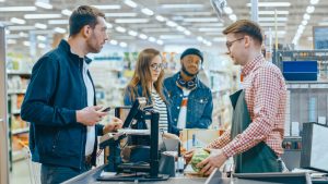 Customers checking out groceries at a grocery store.