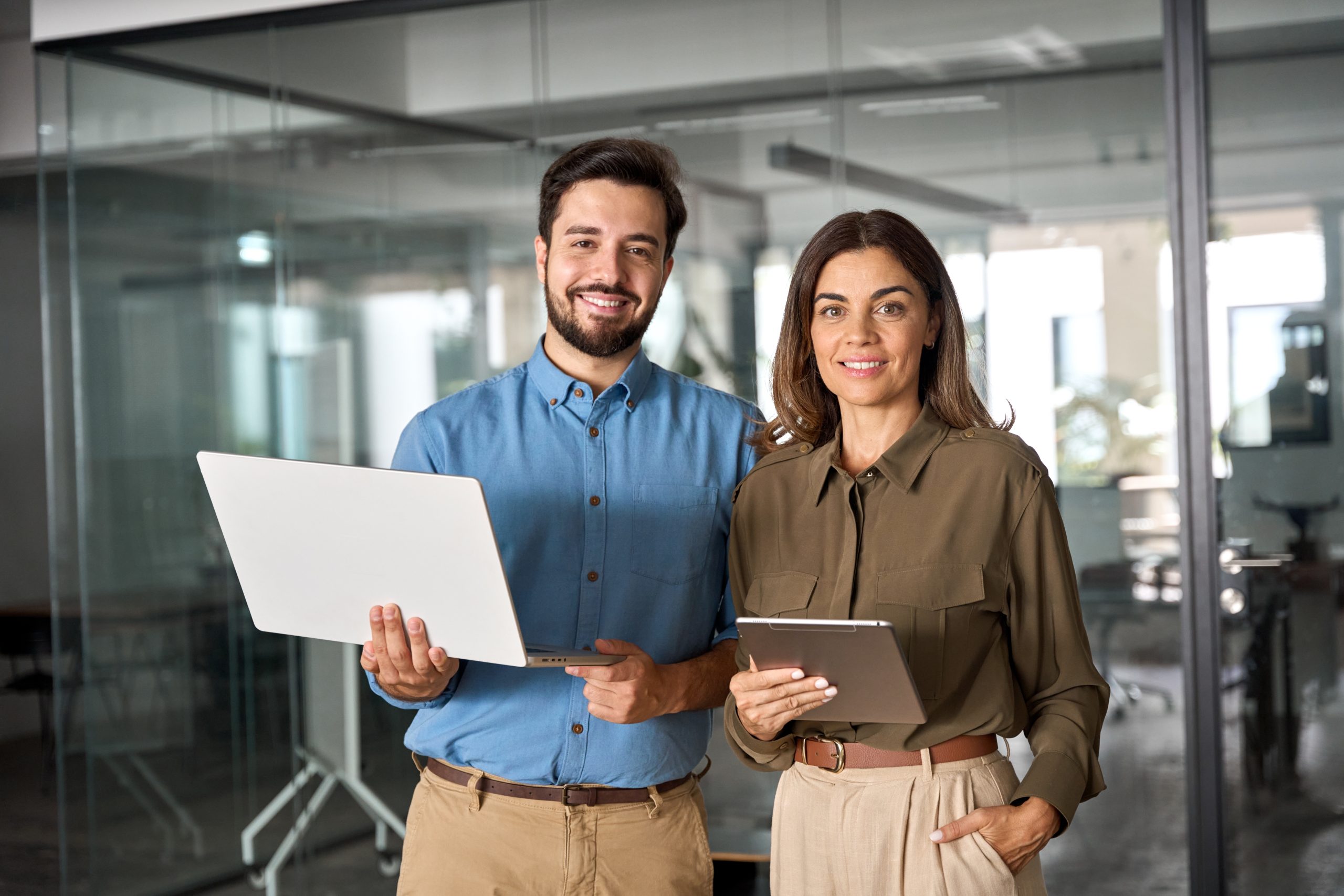 Two professionals smiling in modern office.