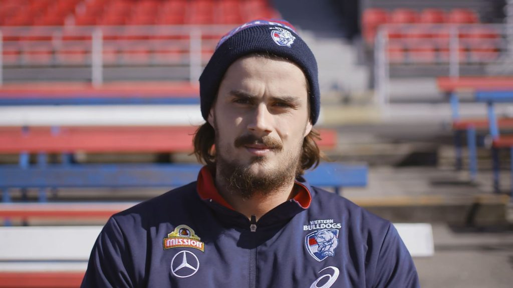 Athlete in team jacket at empty stadium